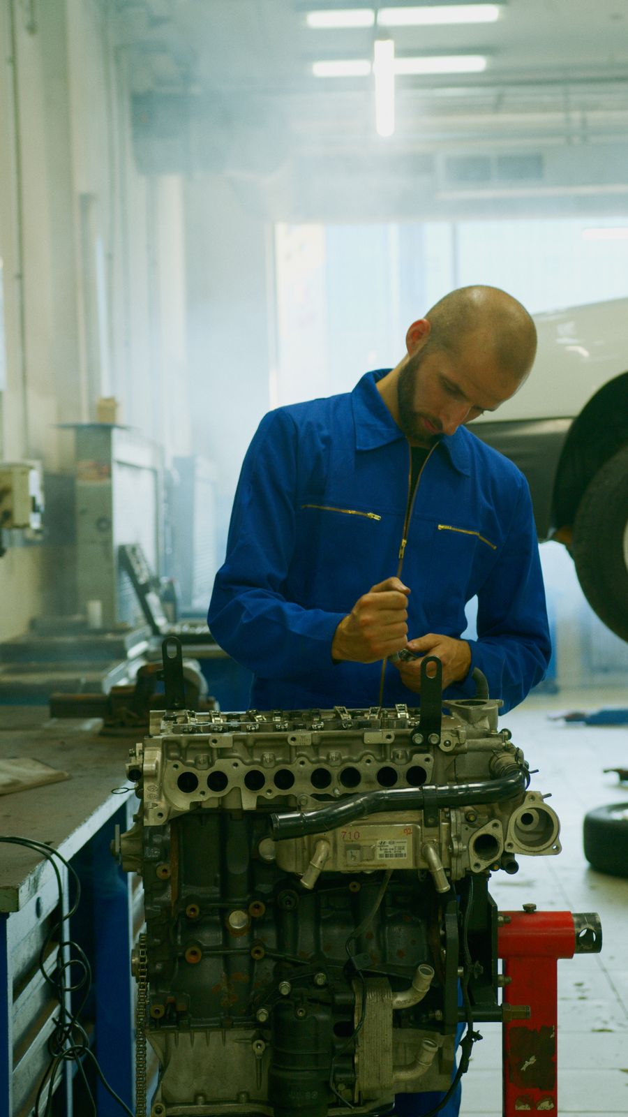 Mechaniker bei Arbeiten am Fahrzeugmotor – Symbolfoto